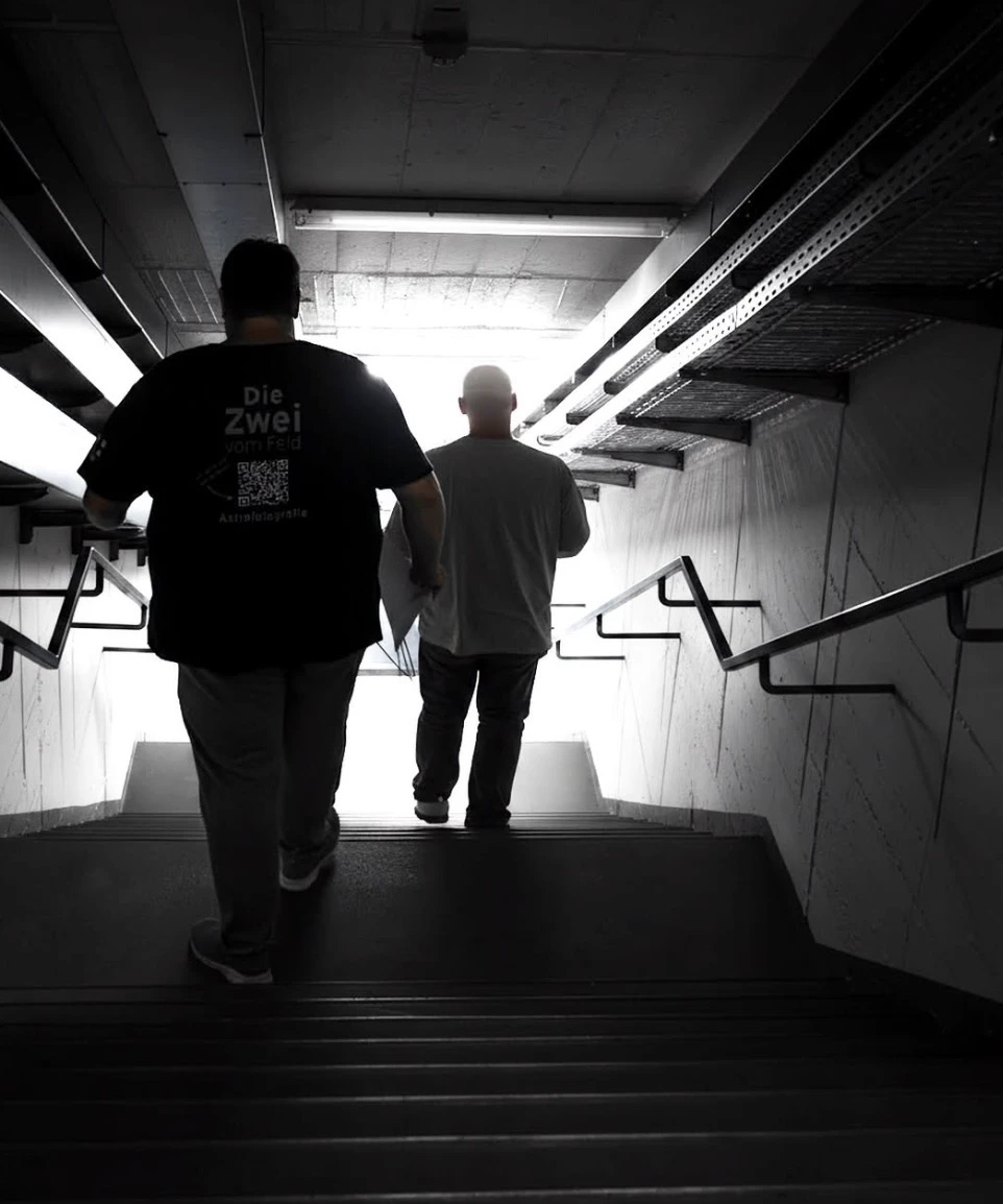 Sven und Tobi von hinten auf einer Treppe ins Licht, auf dem Weg zum Radioteleskop Effelsberg