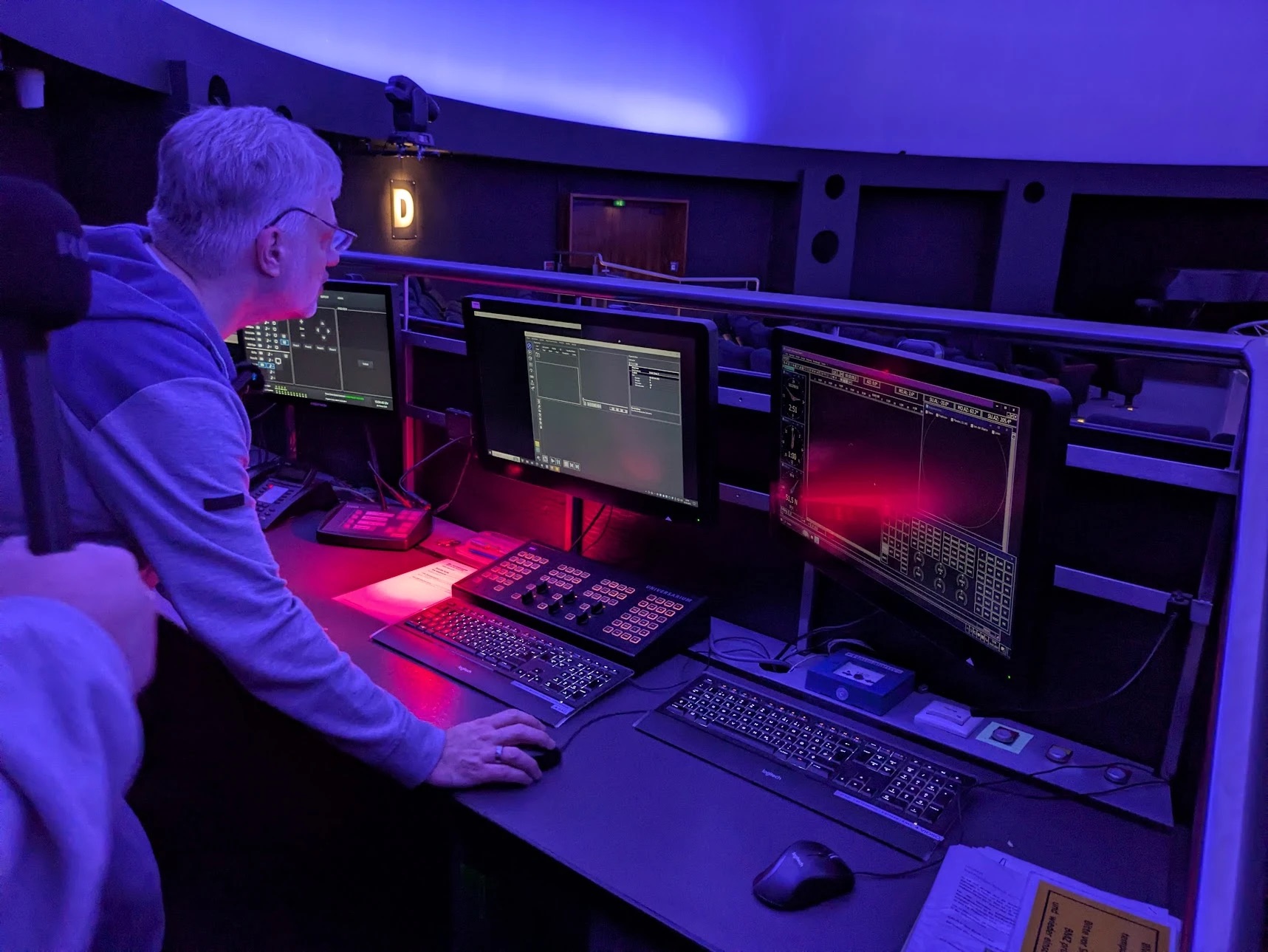 Am Steuerpult des Planetariums Bochum: Monitore, Tastaturen und Bedienpult unter der blau beleuchteten Kuppel